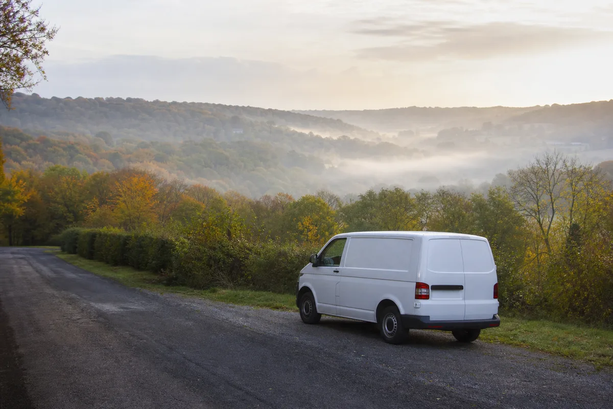 Fourgon d&rsquo;artisan chauffagiste sur une route de bocage dominant la vallée de la Druance